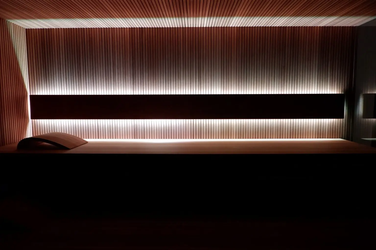 Podświetlana ściana i ławka w nowoczesnej saunie